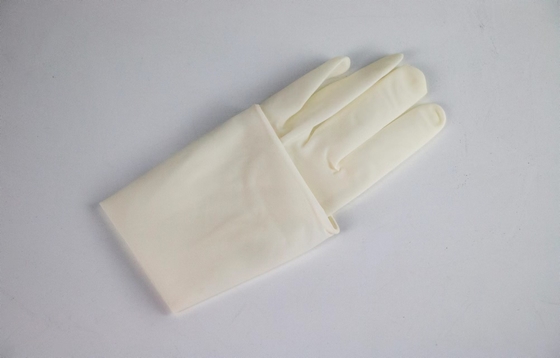 Το ιατρικό χειρουργικό μίας χρήσης χέρι φορά γάντια στο αποστειρωμένο προσαρμοσμένο λατέξ χρώμα